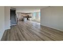 Open-concept living room featuring beautiful hardwood floors, leading into a modern kitchen with a center island at 140 Joyce Dr, Longs, SC 29568