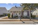Attractive single-story home featuring a welcoming front porch, tasteful landscaping, and an American flag at 1541 Waverly Ave., Myrtle Beach, SC 29577