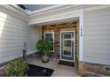 Charming front entryway featuring a decorative glass door, stone accents, and lush landscaping at 1829 Wood Stork Dr., Conway, SC 29526