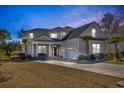 Two-story house exterior at dusk, featuring landscaping and a driveway at 2060 Summer Rose Ln., Myrtle Beach, SC 29579