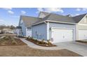 Townhome exterior showcasing a side view with garage and landscaping at 2602 Blue Crane Circle # 101, Myrtle Beach, SC 29577