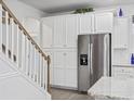 Bright kitchen featuring white cabinets, stainless steel appliances, and convenient staircase access at 2602 Blue Crane Circle # 101, Myrtle Beach, SC 29577