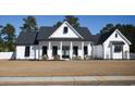Inviting home exterior with white siding, black shutters, and rocking chair front porch at 261 Marsh Tacky Loop, Myrtle Beach, SC 29588