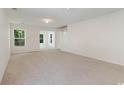 Bright living room with neutral carpeting and access to a sunroom at 396 Bellegrove Dr., Myrtle Beach, SC 29579