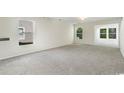 Open living room showcasing neutral carpeting and ample natural light at 396 Bellegrove Dr., Myrtle Beach, SC 29579