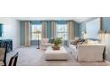 Well-lit living room with blue walls, neutral sofas, decorative pillows, and light-colored carpet at 405 Sun Colony Blvd., Longs, SC 29568