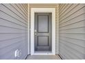 Close-up of a gray front door with white trim, showcasing the home's entryway at 409 Sun Colony Blvd., Longs, SC 29568