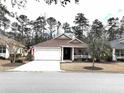 Traditional-style home with an attached two-car garage, neutral siding, and a welcoming front porch at 414 Grand Cypress Way, Murrells Inlet, SC 29576