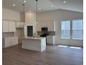 Modern kitchen with white cabinets, stainless steel appliances, and a center island with bar seating at 456 Sun Colony Blvd., Longs, SC 29568