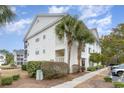 Exterior side of condo building showing sidewalk, greenery, and balconies at 659 Woodmoor Dr. # 103, Murrells Inlet, SC 29576