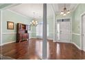 Bright dining room featuring hardwood floors, a chandelier, decorative columns, and a large window at 720 Dove Haven Ln., Myrtle Beach, SC 29579