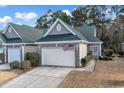 Tan colored house with a green roof, two car garage and American flag at 842 Pinehurst Ln. # 88D, Pawleys Island, SC 29585