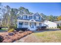 Charming two-story home featuring a lovely front porch and well-maintained landscaping at 116 Great Lakes Rd., Pawleys Island, SC 29585