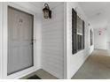 Building entry with gray door, white siding, and black shutters at 136 Birch N Coppice Dr. # 11, Surfside Beach, SC 29575