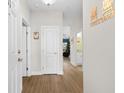 Hallway with wood floors, white doors and trim, and a decorative welcome sign at 136 Birch N Coppice Dr. # 11, Surfside Beach, SC 29575