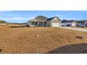 One-story house with gray siding, white garage door, and a spacious yard at 142 Bancroft Dr., Conway, SC 29527