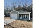 Newly built home with a green exterior, two-car garage, and a small front yard at 150 Honeydew Rd., Myrtle Beach, SC 29588