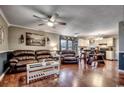 Open living room with hardwood floors, brown leather furniture, and a kitchen view at 1500 Docksider Ct., Surfside Beach, SC 29575