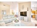 Bright living room with white sofas, neutral carpet, modern decor, and a view into the kitchen at 2110 Green Heron Dr., Murrells Inlet, SC 29576