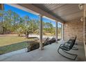 Covered front porch framed by stately columns, offering a serene view of the landscaped front yard at 2531 Smiley Ln., Conway, SC 29526