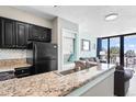 Granite counters accent this well-equipped kitchen with an adjacent stackable washer/dryer at 2700 N Ocean Blvd. # 253, Myrtle Beach, SC 29577