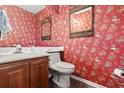 Stylish half bathroom featuring red patterned wallpaper, a sleek vanity, and modern fixtures at 4396 Baldwin Ave. # 94, Little River, SC 29566