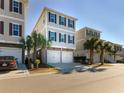 Attractive three-story beach home boasting a two-car garage and lush palm trees at 4904 Salt Creek Ct., North Myrtle Beach, SC 29582