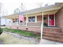 Inviting brick front porch with columns, red door and American flag at 604 Six Lakes Dr., Myrtle Beach, SC 29588