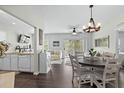 Open floor plan with a dining area, chandelier and luxury vinyl flooring overlooking a cozy living room at 6208 Sweetwater Blvd. # 6208, Murrells Inlet, SC 29576