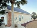 Side view of the home showcasing the blend of siding and brick, the roofline, and the manicured landscaping at 8304 Parasol Ct., Myrtle Beach, SC 29579