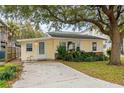 Charming yellow home with a well-manicured lawn and mature tree providing ample shade at 913 S Dogwood Dr. S, Surfside Beach, SC 29575