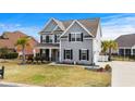 Beautiful two-story home with gray siding, black shutters, manicured lawn and a two car garage at 931 Desert Wheatgrass Dr., Myrtle Beach, SC 29579