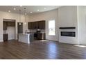 Open concept view showcasing kitchen island, stainless appliances, modern fireplace, and wood flooring at 148 Joyce Dr, Longs, SC 29568