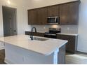Close up of the kitchen island, sink, stainless steel appliances, and wooden cabinets at 148 Joyce Dr, Longs, SC 29568