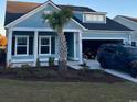 Inviting home with a palm tree, blue siding, black shutters, and an attached garage at 2006 Lone Cypress Dr, Myrtle Beach, SC 29579