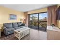 Relaxing living room with a sofa, coffee table, and balcony access at 210 75Th Ave N # 4032, Myrtle Beach, SC 29572