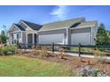 View of a single-story home featuring a two-car garage, well-manicured lawn, and landscaped front yard at 2501 Brescia St., Myrtle Beach, SC 29579
