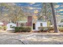 Quaint home showcasing a classic brick chimney, green metal roof, and welcoming entrance at 2505 Redwood St., Georgetown, SC 29440