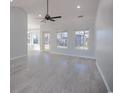Bright living room featuring gray floors, large windows, and a ceiling fan at 260 Barclay Dr., Myrtle Beach, SC 29579