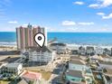 Scenic aerial view showcasing the condo building near ocean, sandy beach, and a pier in a vibrant coastal community at 3401 N Ocean Blvd. # 109, North Myrtle Beach, SC 29582