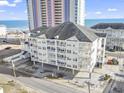 Exterior of the condo building showing its coastal location near a sandy beach and a pier at 3401 N Ocean Blvd. # 109, North Myrtle Beach, SC 29582