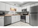 Well-lit kitchen with white cabinets, stainless steel appliances, and tile flooring at 416 Cambridge Circle # H5, Murrells Inlet, SC 29576