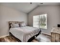 Cozy bedroom featuring vaulted ceilings, wood floors, a comfortable bed, and a bright window at 4225 Rivergate Ln., Little River, SC 29566