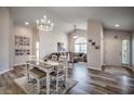 Bright open-concept living and dining area with hardwood floors, modern lighting, and a view to the front entrance at 4225 Rivergate Ln., Little River, SC 29566