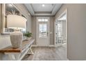 Welcoming entryway with wood floors, console table, decorative lamp, and transom window above the front door at 2505 Brescia St., Myrtle Beach, SC 29579