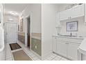 Inviting hallway with white tile flooring, leading to a doorway and a small wet bar area at 679 Riverwalk Dr. # 302, Myrtle Beach, SC 29579