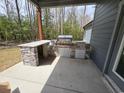 Outdoor kitchen with built-in grill, granite counters, and stone accents on the covered patio at 8012 Old Reaves Ferry Rd., Conway, SC 29526