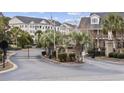 Gated community entrance with manicured landscaping and visible flags adding prestige at 805 Sunswept Ct. # 102, Murrells Inlet, SC 29576