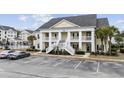 Inviting condo exterior showcasing large columns and a double staircase entry with ample parking spaces at 805 Sunswept Ct. # 102, Murrells Inlet, SC 29576