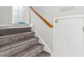 Carpeted staircase with wooden handrail and closet; beach decor adds a touch of seaside charm at 120 Brentwood Dr. # E, Murrells Inlet, SC 29576